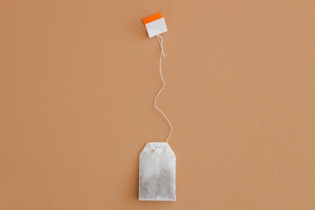 Tea bag with label on beige background space for text