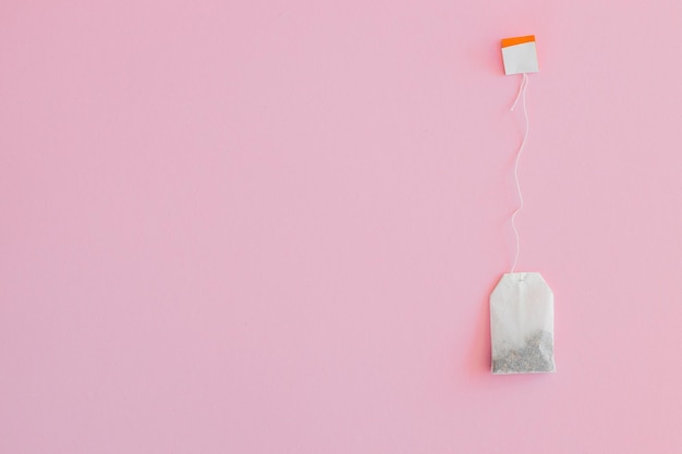 Tea bag with label on pink background space for text