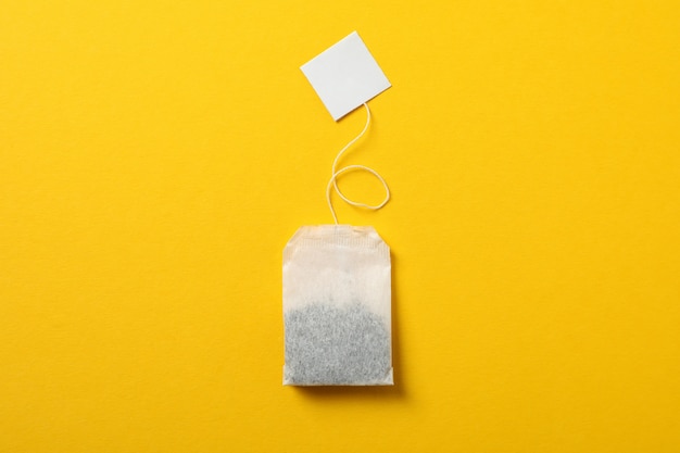 Tea bag with label on yellow, space for text