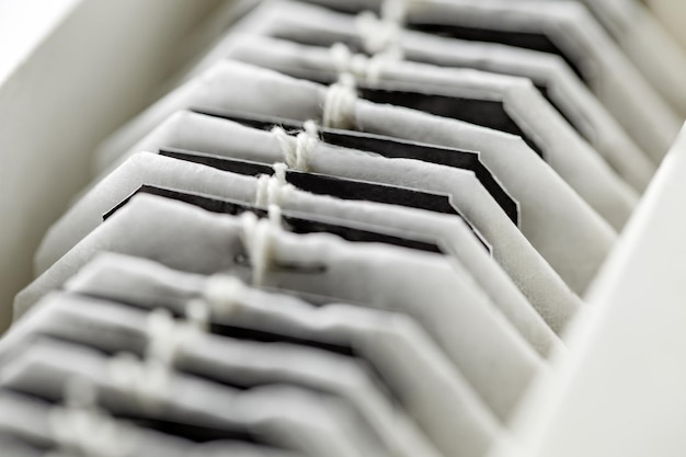 Tea bags are stacked in row in box selective focus