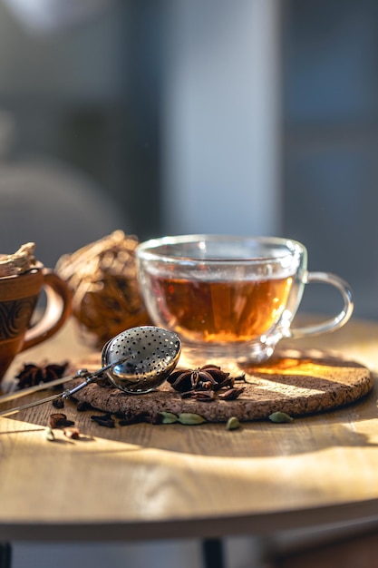 Tea ceremony glass cup of black tea and teapot on blurred home background