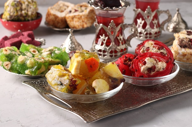 Tea ceremony with Turkish sweets on metal tray on gray background. Close-up. Horizontal format