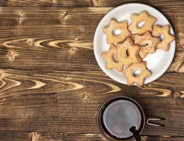 Tea and cookies on wooden background copy space