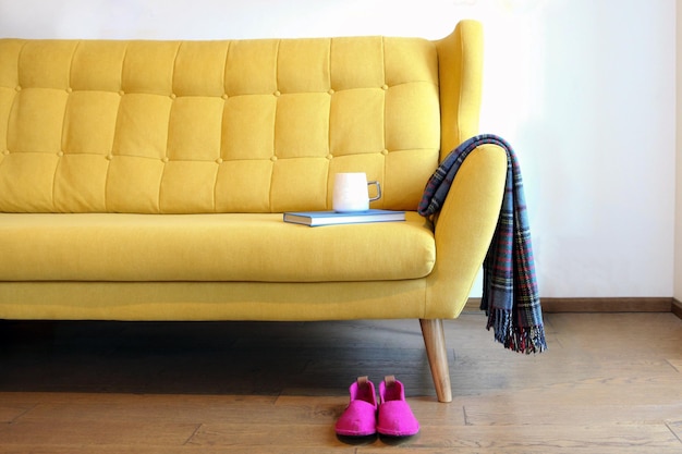 Tea Cup and blue book on yellow coach Still life home interior living room Cozy comfort Modern home