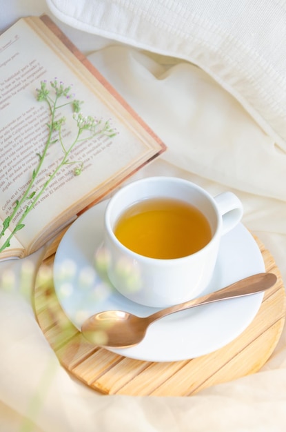 Tea cup next to book and leaves Relax moment