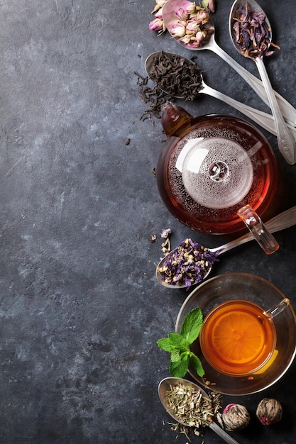 Tea cup teapot and assortment of dry tea in spoons