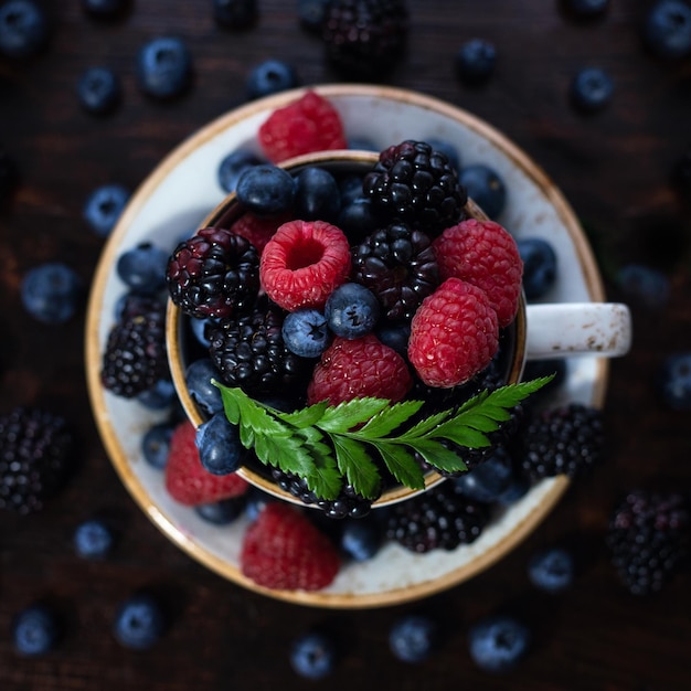 Tea Cup with berries closeup on a dark background