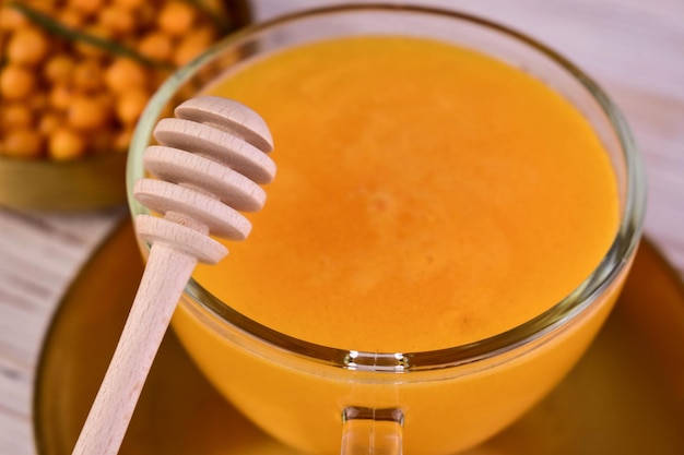 Tea from sea buckthorn berries in a cup Closeup