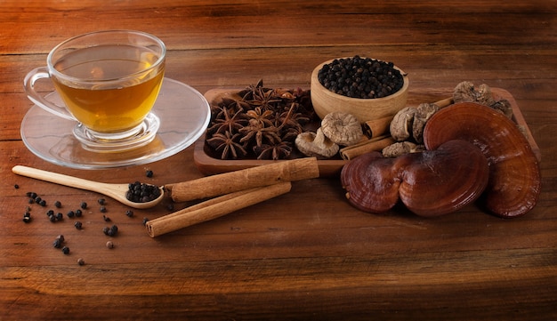 Tea lingzhi black pepper cinnamon star anise on wood