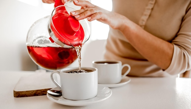 Tea preparation with teapot and cups at kitchen