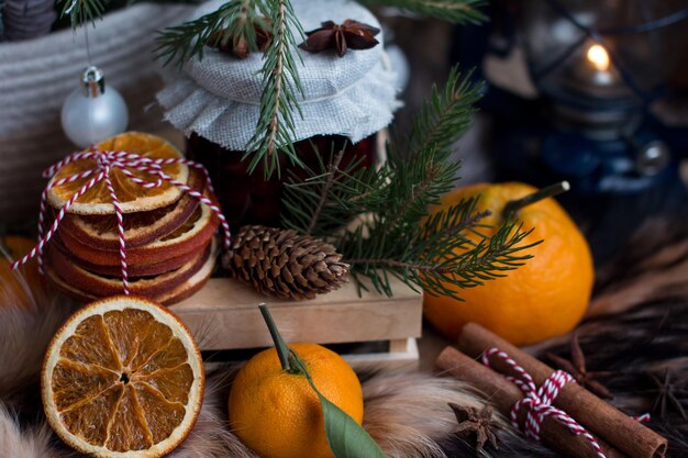 tea set dry orange slices for mulled wine cinnamon sticks and star anise Cold winter in the village Cherry jam on the background of a burning lantern and natural fox fur