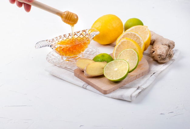 tea with herbs, lemon and ginger on white background and honey