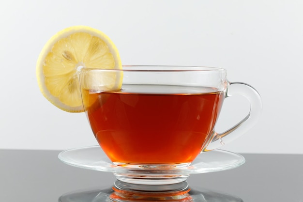 Tea with lemon in a cup Black tea with a slice of lemon in a glass mug