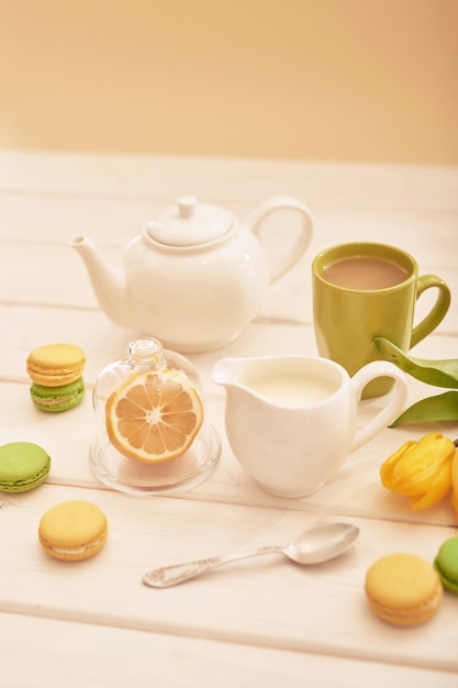 tea with mint and lemon on the table with macaroons and yellow tulips