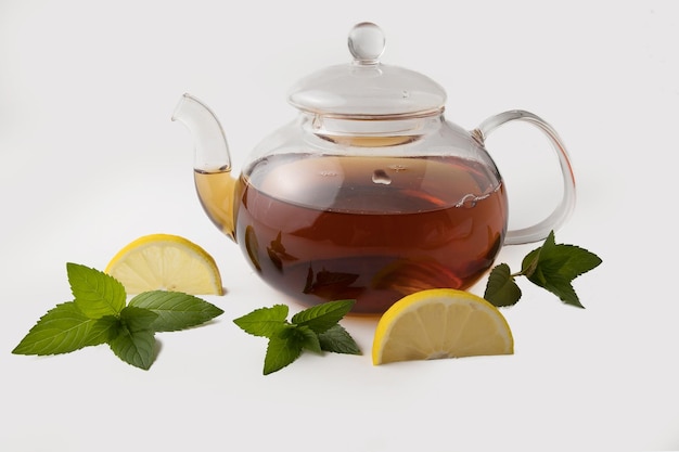 Tea with mint and lemon in a transparent bowl on a light background