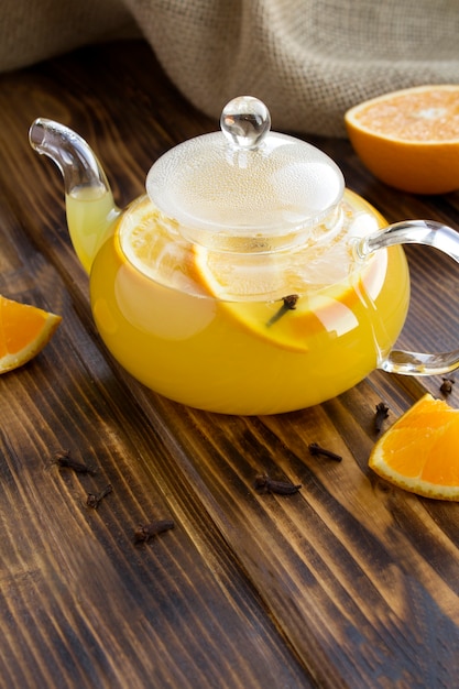 Tea with orange and cloves in the glass teapot