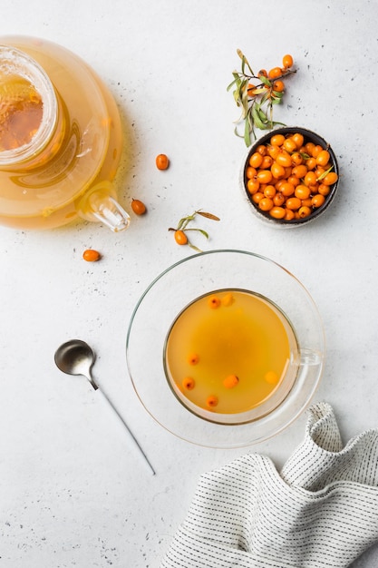 Tea with sea buckthorn on white stone background. top view