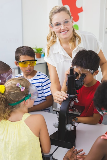 Teacher assisting kids in laboratory