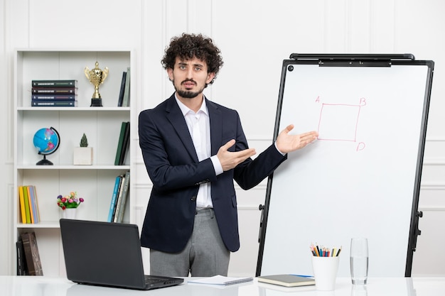 Teacher brunette instructor with computer in suit and whiteboard in classroom presenting board