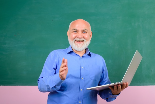 Teacher in classroom near blackboard teacher giving lesson to students education school people