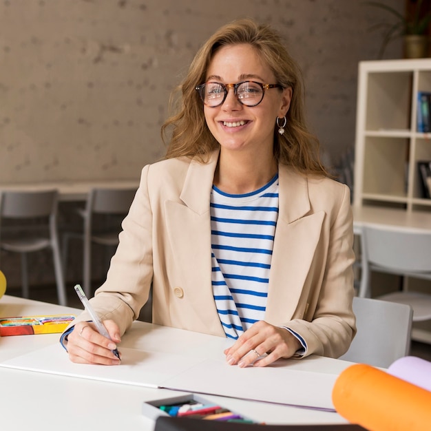 Teacher at desk writing