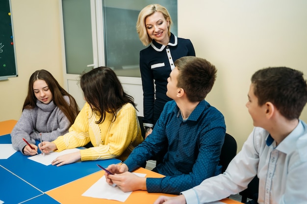 Teacher of english explaining lesson in front of teenage students. Educational concept.