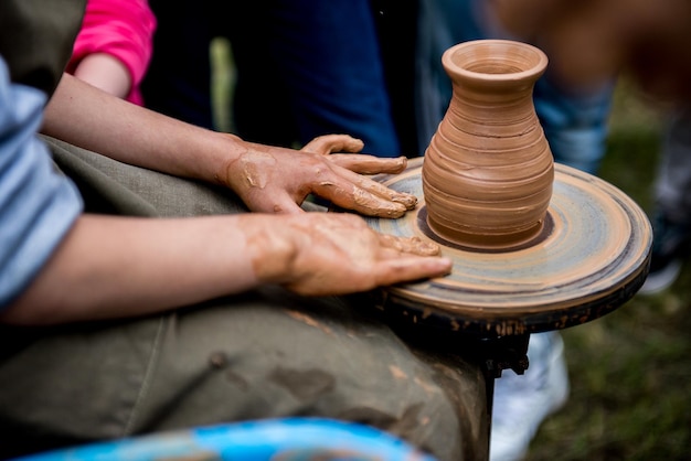 the teacher helps his student to work with clay. Work on the potter's wheel.