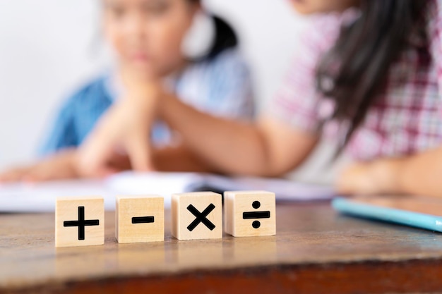 The teacher is teaching an Asian girl They are learning math Mathematical signs addition subtraction multiplication and division