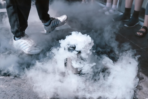 The teacher making an chemical and physical experiment with liquid nitrogen or dry ice Fog and steam are spreading through the class