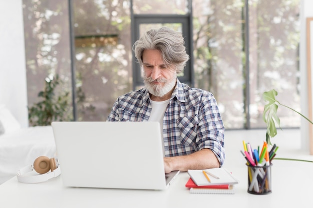 Teacher staying at desk using laptop