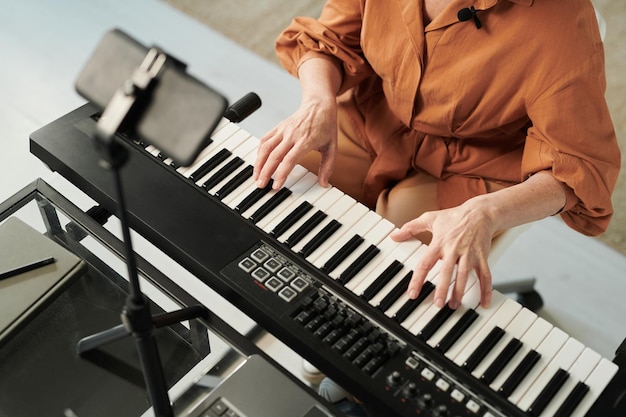 Teacher teaching her student to play piano