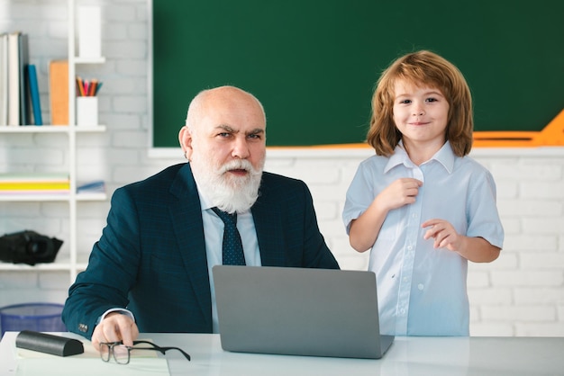 Teacher with schoolboy in classroom Pupil with laptop Education and learning Teacher help to learn Happy lessons Back to school