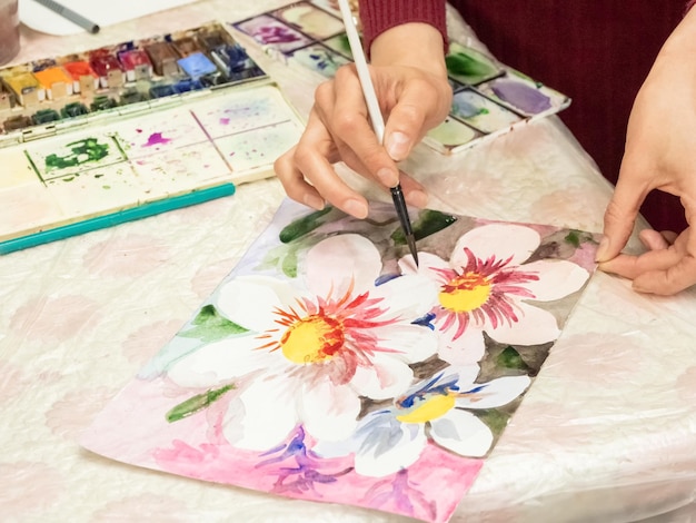 Teaching drawing Brush in the hands of the artist watercolor painting creativity with many colors