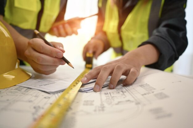 Team of architects discussing working together on construction plans at modern office