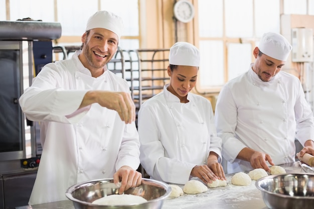 Team of bakers preparing dough