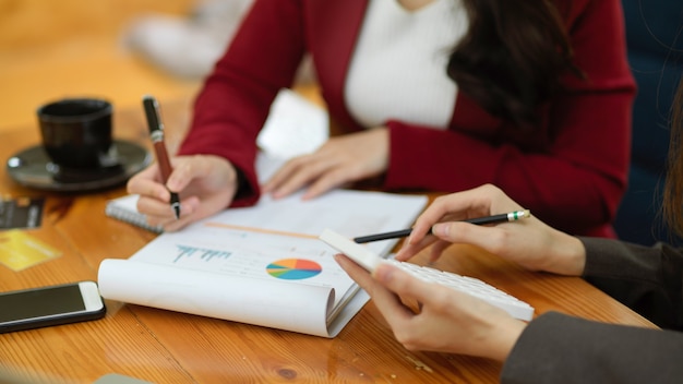 A team of business strategy consultants is working together reviewing financial report papers