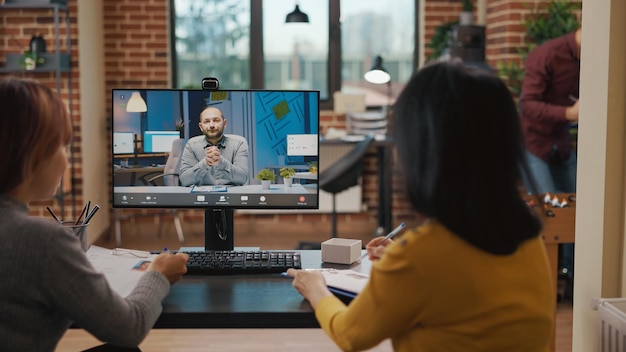 Team of colleagues meeting with man on online video call at job interview. Asian women attending recruitment call with candidate, using remote videoconference to discuss about hiring.