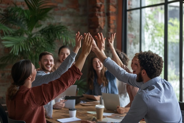 A team of coworkers celebrating with highfives and