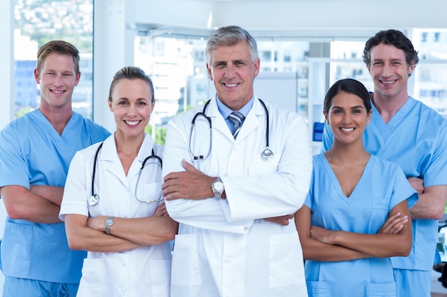 Team of doctors standing arms crossed and smiling at camera