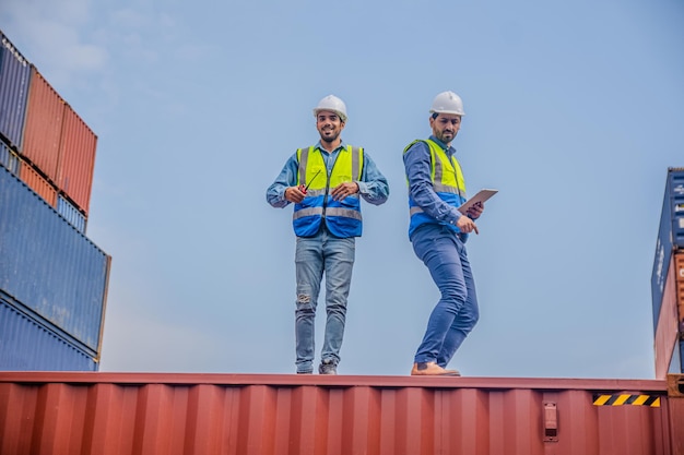 Team Engineers are inspecting the transportation of cargo with containers inside the warehouse Container in export and import business and logistics