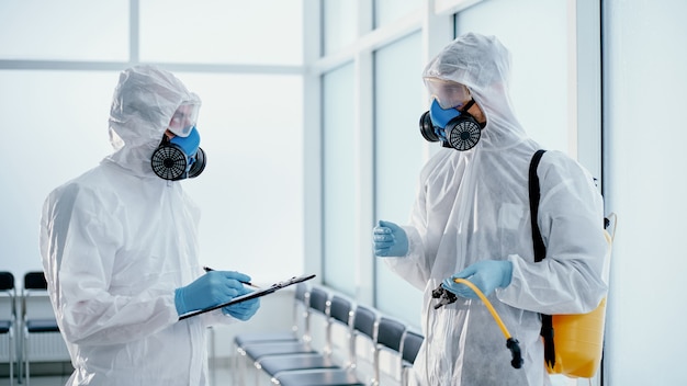 Team of professional disinfector making a record of the work done