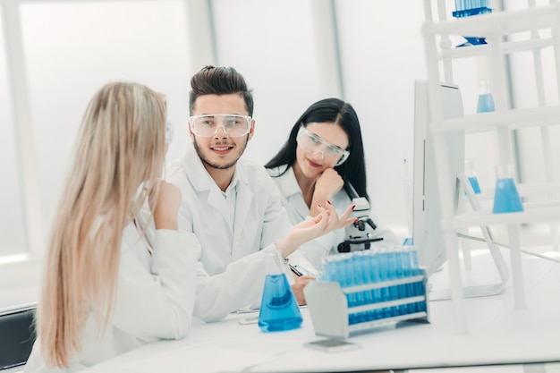 team of scientists discussing something at the Desk .