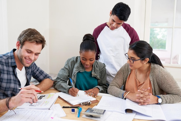 Team students and writing notes in university for learning knowledge or brainstorming together College friends and happy people studying for information education and help for math exam in class