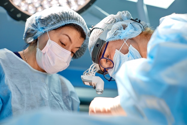 Team of surgeons makes an invasive operation