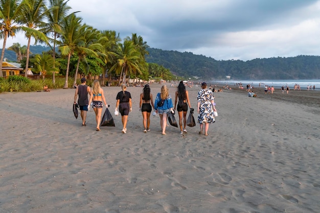 Team of vigorous recycling volunteers collecting plastic rubbish into bags Save the planet