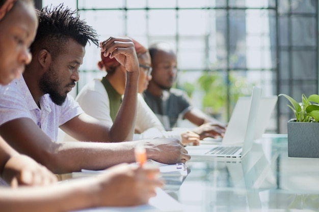 Team of young african people in the office at the table with a laptop