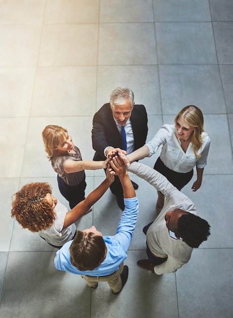 Teamwork always wins High angle shot of a group of colleagues giving each other a high five in solidarity