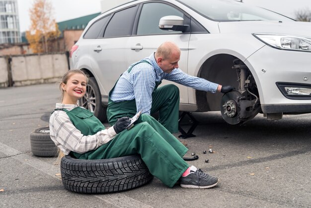 Teamwork on car service station, brake disk checking