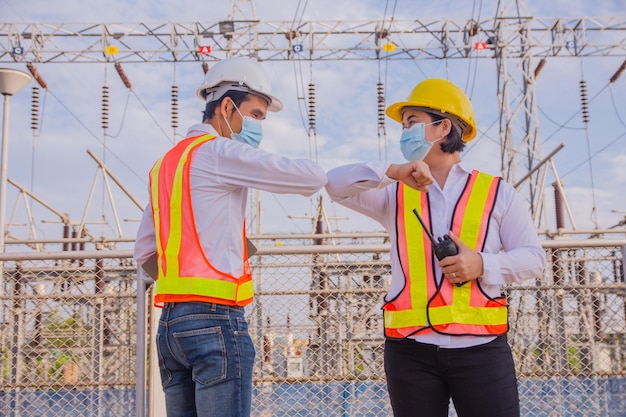 Teamwork Electrician Engineer standing on factory power plant Teamwork Electrician Engineer concept