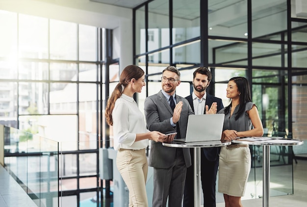 Teamwork is the quickest way to success Shot of a group of colleagues discussing business in the office